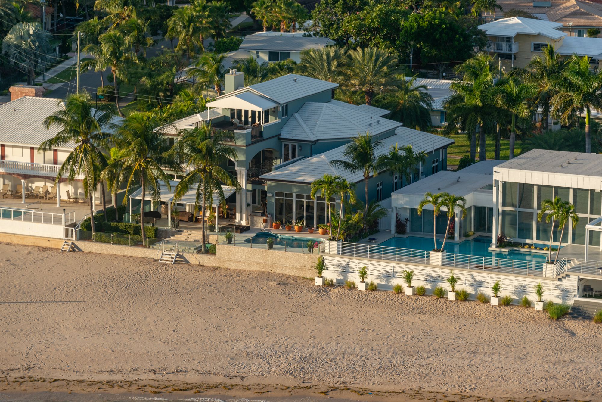 Aerial of luxury beachfront homes with pools